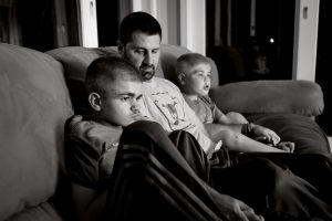 Ryan Kapes, 11, left, with his dad Carl and brother Brayden, 8, watch The Backyardigans at their home in Wilmington, Delaware. Ryan has Sanfilippo Syndrome, a genetic disease that attacks the central nervous system. Most children with the condition die before the age of 20.